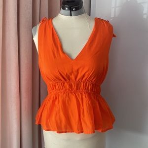orange peplum top with tassel shoulder detail